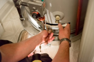 man performing maintenance or repair on water heater