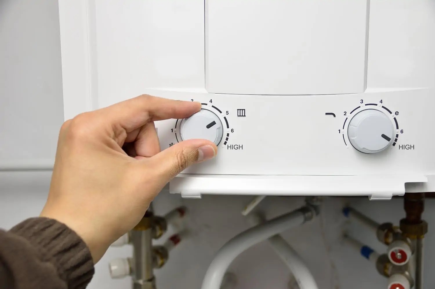 Homeowner adjusting the temperature setting on their tankless water heater