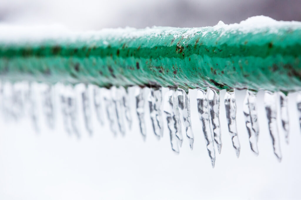 Frozen pipe with icicles hanging down from it