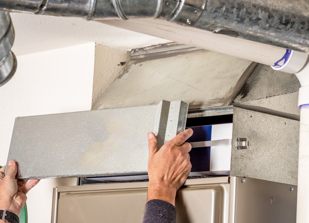 HVAC technician removing panel from furnace