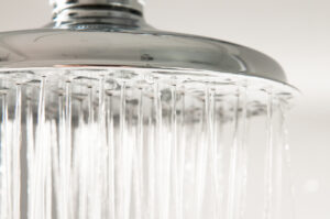 Close-up of water falling from a chrome shower head.