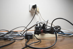 Crowded outlet with cords to depict making buzzing sound