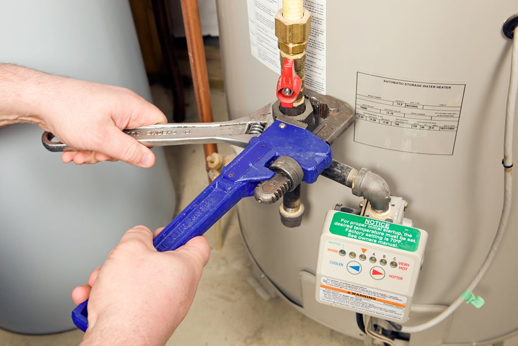 Plumber about to flush a water heater