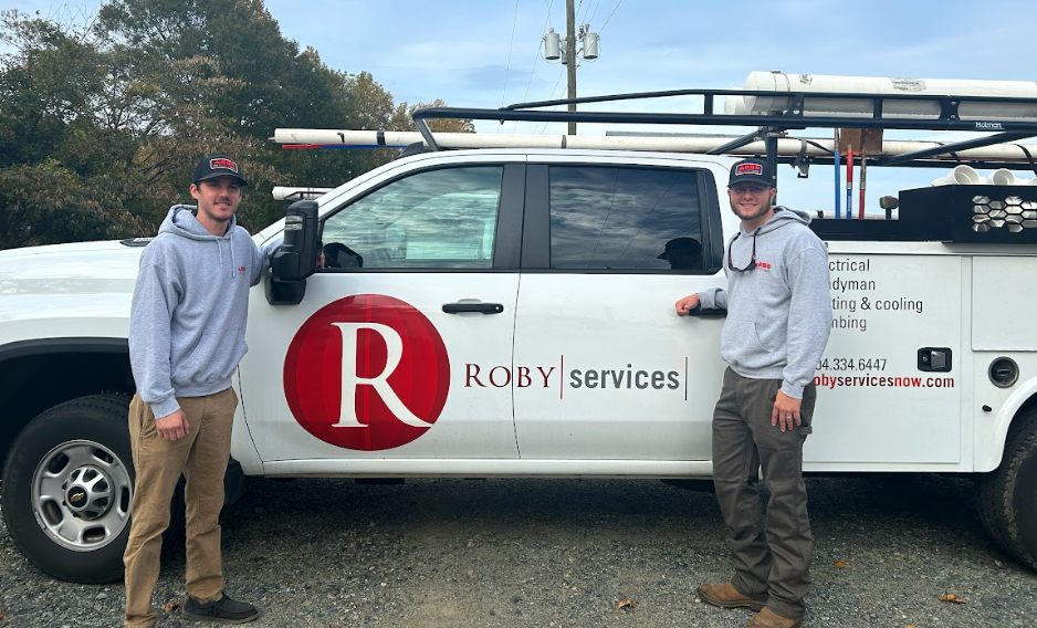 Two Roby Services technicians posing in front of work truck